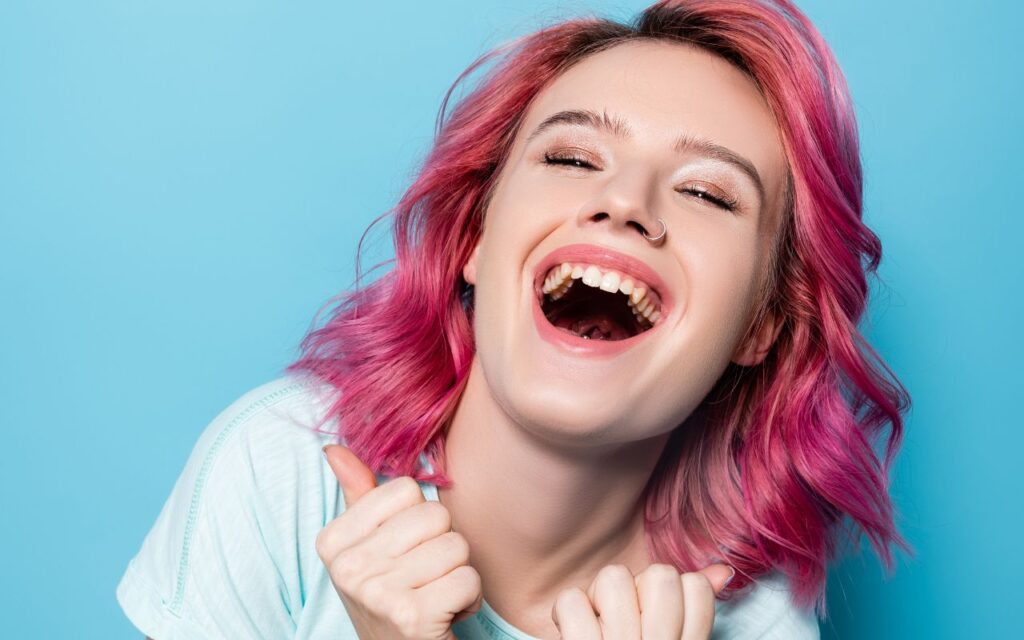 Young woman with pink hair laughing