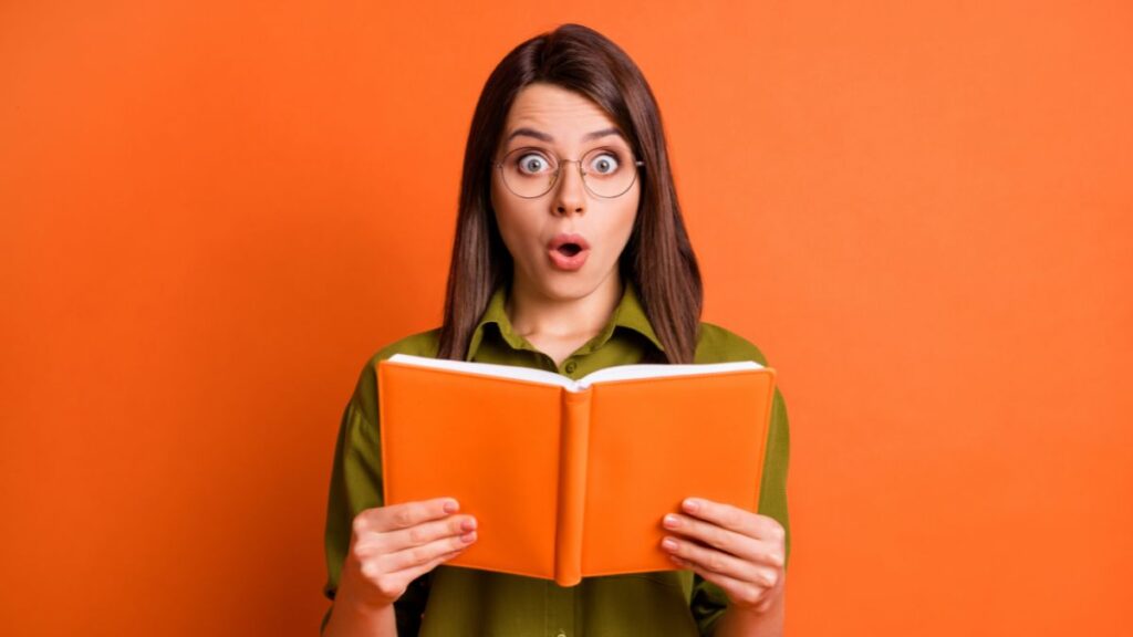 woman shocked reading a book